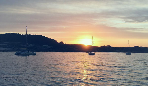 Imagen de veleros en un atardecer en las rias baixas